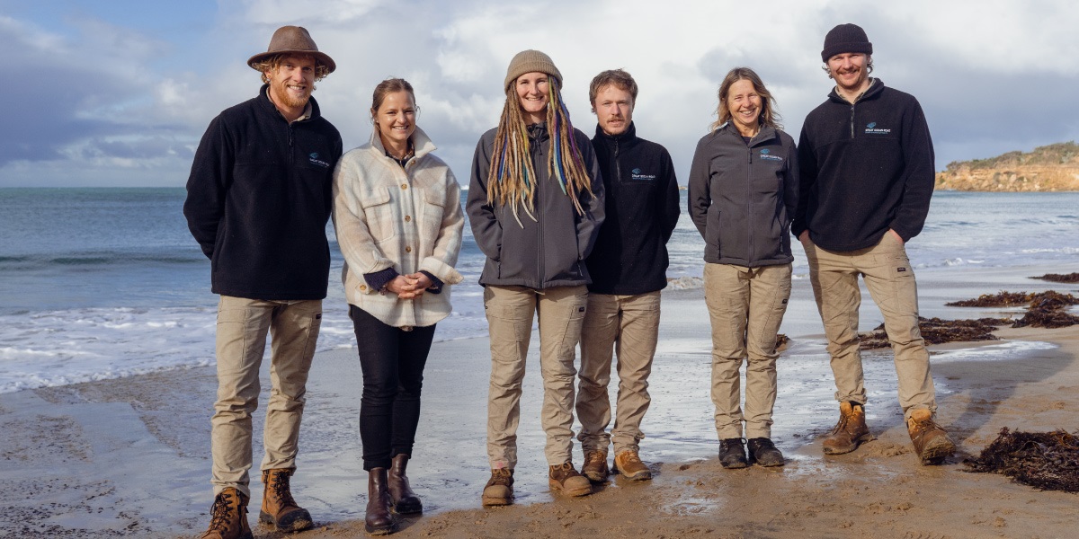 The Great Ocean Road Coast and Parks Authority Conservation Team stand on Point Roadnight beach.